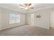 Spacious Primary bedroom featuring a tray ceiling, neutral carpet, and a doorway to a closet at 553 Sturgeon St, Smithfield, NC 27577