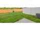The backyard boasts freshly cut grass, a concrete pad, and a white fence at 5560 Henley Ridge Dr # 187, Graham, NC 27253