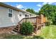 Exterior view showcasing the backyard with deck, lawn, and mature trees at 6016 Farm Gate Rd, Raleigh, NC 27606