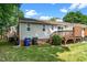 Exterior view of home with deck, showcasing the well-maintained lawn and surroundings at 6016 Farm Gate Rd, Raleigh, NC 27606