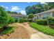 Landscaped walkway leading to the home's entrance, surrounded by lush greenery at 6016 Farm Gate Rd, Raleigh, NC 27606