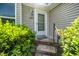 Close-up of the front door with sidelight windows and attractive exterior lighting at 6016 Farm Gate Rd, Raleigh, NC 27606