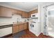 Charming kitchen featuring wood cabinets, white appliances, and a stainless-steel sink at 6016 Farm Gate Rd, Raleigh, NC 27606