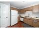 Functional kitchen with wood cabinets, white appliances, and hardwood floors at 6016 Farm Gate Rd, Raleigh, NC 27606
