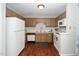 Functional kitchen with wood cabinets, white appliances, and hard wood floors at 6016 Farm Gate Rd, Raleigh, NC 27606
