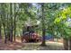 Backyard view of home with wooden deck and lush trees at 605 Catlin Rd, Cary, NC 27519