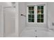 Bright bathroom with a large soaking tub and natural light from the large window at 605 Catlin Rd, Cary, NC 27519