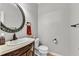 Stylish half bathroom features a decorative mirror, vanity with marble top, and toilet at 605 Catlin Rd, Cary, NC 27519
