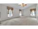 Bright carpeted bedroom with ceiling fan and large windows with draperies at 605 Catlin Rd, Cary, NC 27519