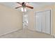 Bedroom with neutral carpet, ceiling fan, closet, and an open door at 605 Catlin Rd, Cary, NC 27519
