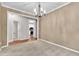 Dining room with adjacent kitchen, featuring a chandelier, beige walls and carpet at 605 Catlin Rd, Cary, NC 27519