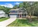 Charming two-story home with a blue exterior, red door, white trim, and a lush green lawn at 605 Catlin Rd, Cary, NC 27519