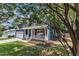 Charming two-story home with a blue exterior, red door, white trim, and a green lawn with mature trees at 605 Catlin Rd, Cary, NC 27519