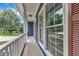Charming covered front porch with white railings and views of the surrounding greenery at 605 Catlin Rd, Cary, NC 27519