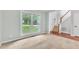 Bright living room with large windows offering a view of the front yard and a staircase to the second floor at 605 Catlin Rd, Cary, NC 27519