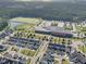 Aerial view of a residential area near a school with an athletic field, surrounded by trees at 6612 Enrichment Ln, Raleigh, NC 27616