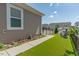 Well-manicured backyard featuring an artificial lawn, garden beds, and cozy seating area at 6612 Enrichment Ln, Raleigh, NC 27616