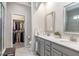 Bathroom with double vanity, tiled floors, large mirror, and a walk-in closet with ample storage at 6612 Enrichment Ln, Raleigh, NC 27616