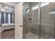 Modern bathroom featuring a glass-enclosed shower with gray tiling and a view into the Primary bedroom at 6612 Enrichment Ln, Raleigh, NC 27616