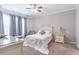 Bright bedroom featuring a queen bed, nightstands, carpeted floors and natural lighting at 6612 Enrichment Ln, Raleigh, NC 27616