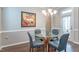 Cozy dining area features a glass table, seating for four, dark hardwood floors and modern lighting at 6612 Enrichment Ln, Raleigh, NC 27616