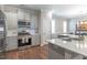 Open kitchen with stainless steel appliances, gas range, white countertops, and a breakfast nook at 6612 Enrichment Ln, Raleigh, NC 27616