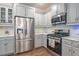 Well-equipped kitchen featuring stainless steel appliances, white countertops, and gray cabinets at 6612 Enrichment Ln, Raleigh, NC 27616
