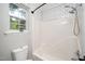 Modern bathroom with black and white tile, shower and bathtub combo, and window with view to the outdoors at 725 E Maple Ln, Fuquay Varina, NC 27526