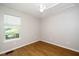 Empty bedroom with hardwood floors, ceiling fan, large window and neutral paint at 725 E Maple Ln, Fuquay Varina, NC 27526