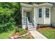 Quaint front entrance framed by lush greenery and vibrant flowers at 725 E Maple Ln, Fuquay Varina, NC 27526