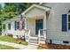 Inviting front entrance with a charming porch, American flag and well-kept landscaping at 725 E Maple Ln, Fuquay Varina, NC 27526