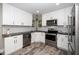 Modern kitchen with stainless steel appliances, white cabinets, and granite countertops at 725 E Maple Ln, Fuquay Varina, NC 27526