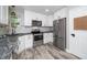 Well-designed kitchen with stainless steel appliances, white cabinetry and granite countertops at 725 E Maple Ln, Fuquay Varina, NC 27526