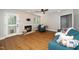 Relaxing living room with ceiling fan, warm fireplace, hardwood floors, and comfortable blue couch and chaise lounge at 725 E Maple Ln, Fuquay Varina, NC 27526