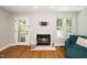 Bright living room features marble fireplace, wooden floors, large windows and white trim at 725 E Maple Ln, Fuquay Varina, NC 27526