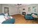 Cozy living room featuring a marble fireplace, ceiling fan, hardwood floors, and comfortable blue furniture at 725 E Maple Ln, Fuquay Varina, NC 27526