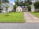 An exterior view of a home highlighting the well-kept lawn, brick-lined driveway, and inviting front porch at 807 Edmund St, Raleigh, NC 27604