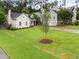 A view of the front yard showing a lush lawn, mature trees, and a well-manicured landscape at 807 Edmund St, Raleigh, NC 27604