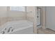 Bathroom showcasing a garden tub, tile surround, and separate glass-enclosed shower at 85 Twelve Oaks Dr, Willow Springs, NC 27592