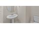 This bathroom features a pedestal sink, oval mirror, and bright, neutral decor at 85 Twelve Oaks Dr, Willow Springs, NC 27592