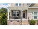 Inviting front porch with stone accents and cozy seating area at 85 Twelve Oaks Dr, Willow Springs, NC 27592