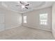 Bright main bedroom featuring neutral carpet, tray ceiling, and double windows at 85 Twelve Oaks Dr, Willow Springs, NC 27592