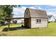 Two-story outdoor storage shed featuring neutral color siding, a gravel floor and an attached open-roofed storage area at 85 Twelve Oaks Dr, Willow Springs, NC 27592