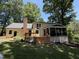 Exterior back of home featuring a deck, patio, screened porch, and brick chimney at 8629 Windjammer Dr, Raleigh, NC 27615