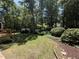 Lush backyard with grass, trees and extensive landscaping including mature shrubbery at 8629 Windjammer Dr, Raleigh, NC 27615