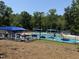 Elevated view of a fenced community pool with lounge chairs and umbrellas at 8629 Windjammer Dr, Raleigh, NC 27615