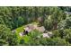 Aerial view of home nestled within lush trees, featuring a screened porch and spacious backyard at 9 Piney Grove Rd, Bahama, NC 27503