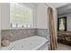 Bathroom featuring a large tub with tiled wall and a decorative window at 9 Piney Grove Rd, Bahama, NC 27503