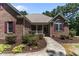Charming brick home featuring manicured landscaping, red shutters, and a covered front porch at 9 Piney Grove Rd, Bahama, NC 27503
