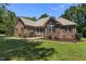 Inviting brick home with manicured lawn, red shutters, and a cozy covered front porch at 9 Piney Grove Rd, Bahama, NC 27503